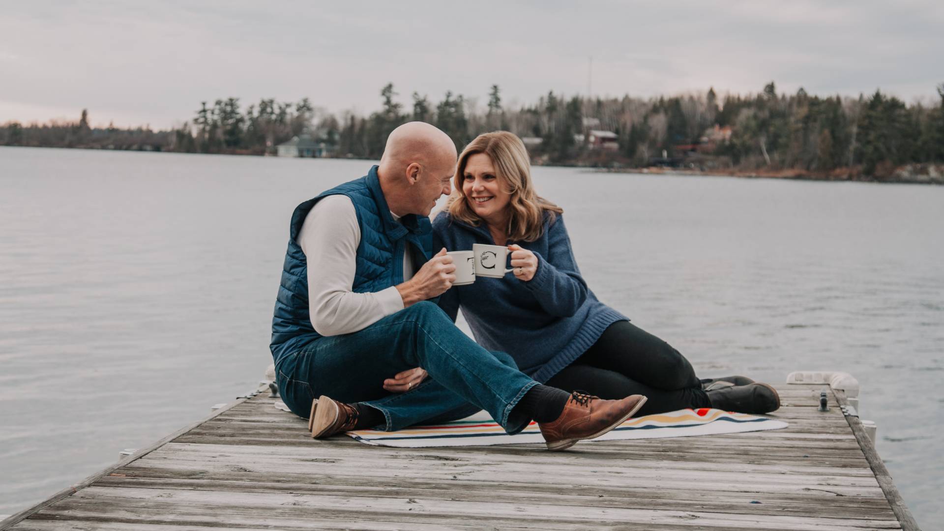Man and woman sitting on a dock by the water